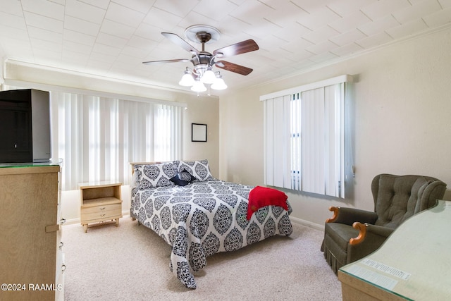 carpeted bedroom with ceiling fan and ornamental molding