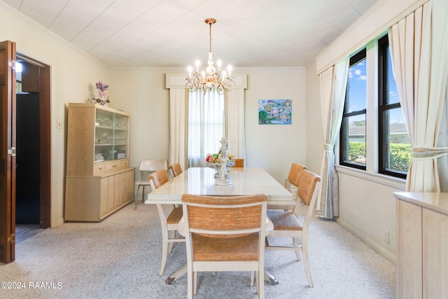 carpeted dining area with an inviting chandelier and ornamental molding