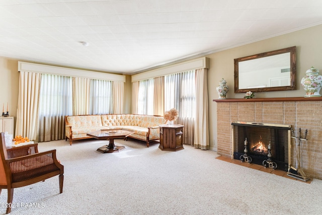 living room featuring carpet floors, a tiled fireplace, and ornamental molding