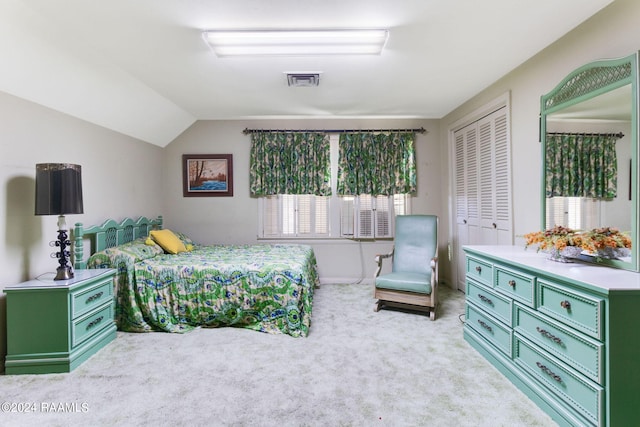 bedroom with light carpet, lofted ceiling, and a closet