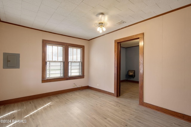 unfurnished room with light hardwood / wood-style flooring, electric panel, and crown molding