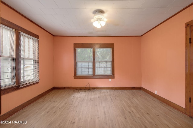 spare room featuring crown molding and light hardwood / wood-style flooring