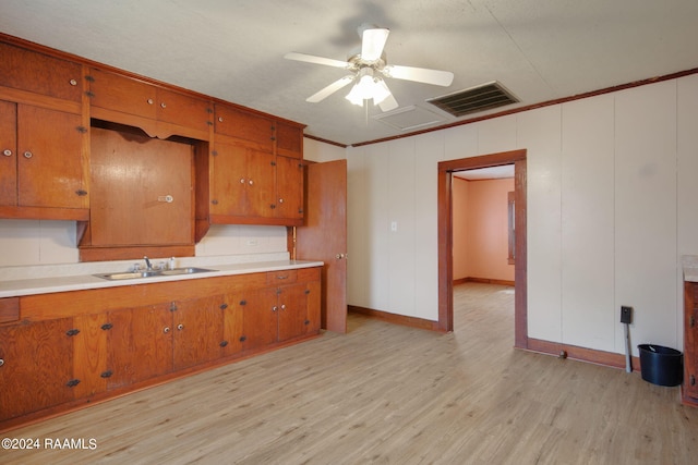 kitchen with crown molding, ceiling fan, light hardwood / wood-style flooring, and sink