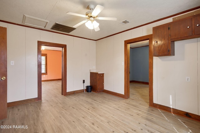 spare room with light hardwood / wood-style flooring, a textured ceiling, ceiling fan, and crown molding