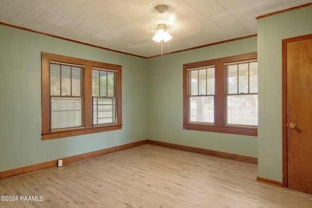 spare room featuring ceiling fan, light wood-type flooring, and ornamental molding