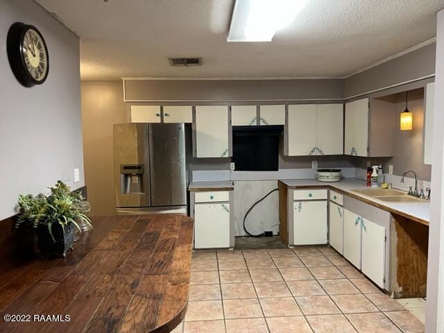 kitchen with hanging light fixtures, sink, stainless steel fridge with ice dispenser, and white cabinets