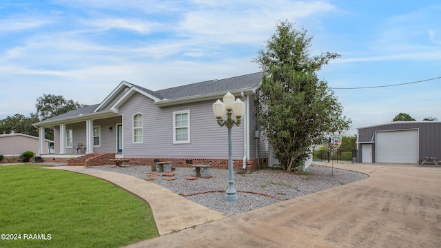 view of front facade with an outdoor structure, a garage, a porch, and a front yard