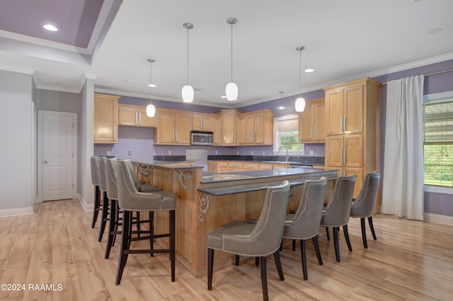 kitchen with pendant lighting, light wood-type flooring, plenty of natural light, and a center island