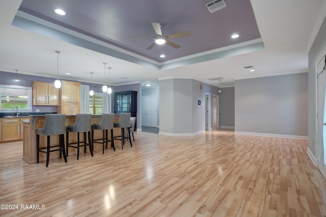 kitchen featuring a breakfast bar area, light wood-type flooring, sink, and a wealth of natural light