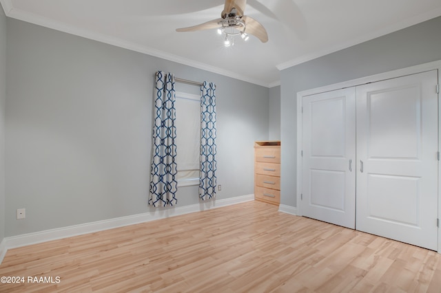 unfurnished bedroom featuring ceiling fan, light hardwood / wood-style flooring, crown molding, and a closet