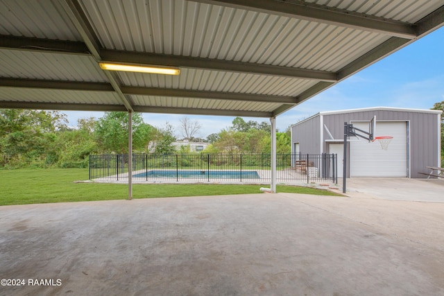 view of patio with an outdoor structure, a garage, and a fenced in pool