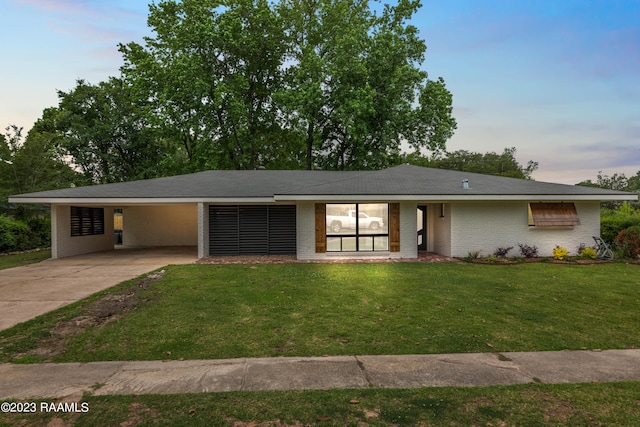 view of front facade featuring a lawn and a carport