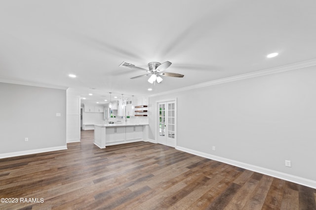 unfurnished living room featuring ceiling fan, dark hardwood / wood-style floors, and ornamental molding