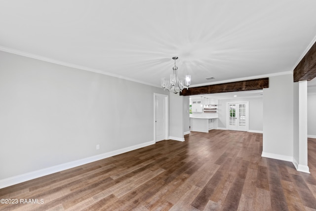 unfurnished living room featuring wood-type flooring, a notable chandelier, and ornamental molding