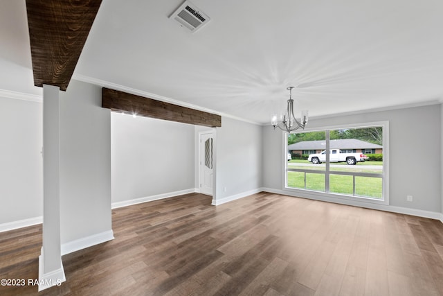 unfurnished living room with an inviting chandelier, crown molding, and dark wood-type flooring