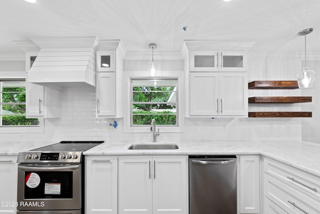 kitchen with white cabinets, appliances with stainless steel finishes, decorative light fixtures, and sink