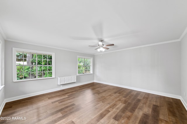 spare room featuring ceiling fan, wood-type flooring, ornamental molding, and radiator heating unit