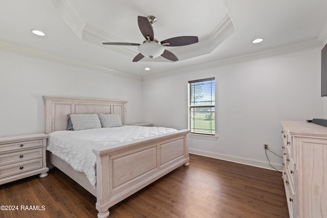 bedroom featuring a raised ceiling, ornamental molding, dark hardwood / wood-style flooring, and ceiling fan