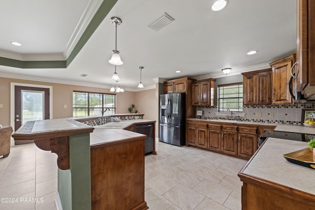 kitchen with stainless steel appliances, hanging light fixtures, tasteful backsplash, and a kitchen island