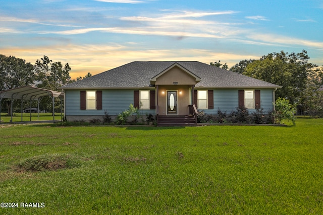 ranch-style home with a lawn and a carport