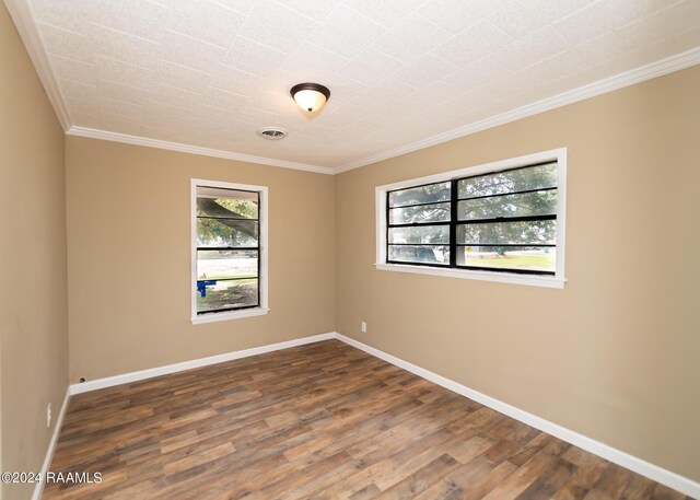 spare room featuring ornamental molding and dark wood-type flooring