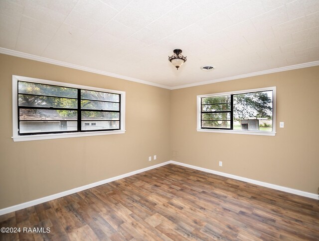 unfurnished room featuring ornamental molding and hardwood / wood-style flooring