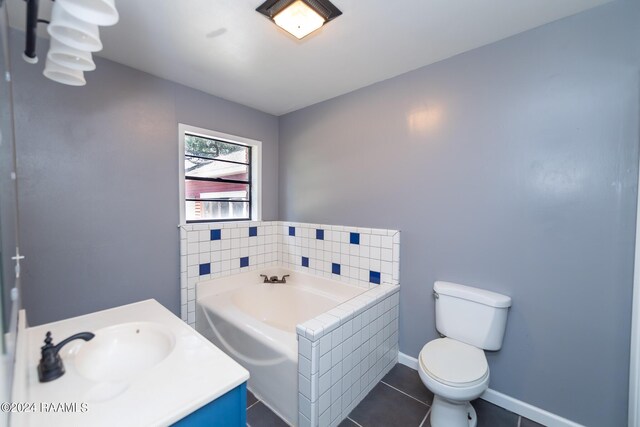 bathroom featuring vanity, tile patterned flooring, a tub, and toilet