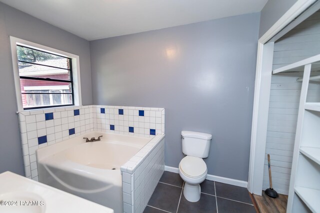 bathroom with tile patterned flooring, toilet, and a bath