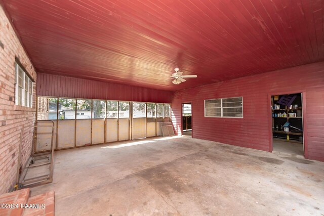 unfurnished sunroom featuring wood ceiling and ceiling fan