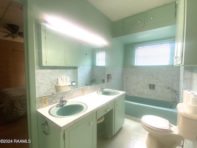 full bathroom with tub / shower combination, vanity, toilet, and tasteful backsplash