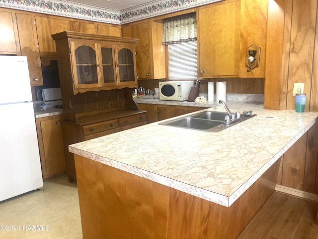 kitchen featuring sink, light hardwood / wood-style floors, kitchen peninsula, and white appliances