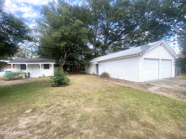 view of yard featuring a garage and an outbuilding