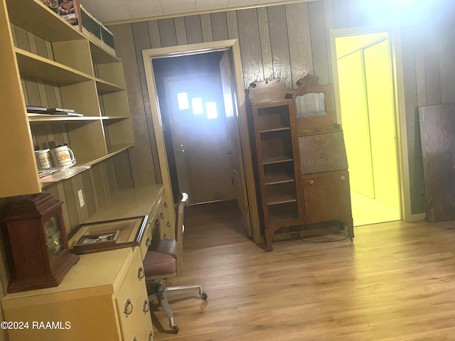 office with light wood-type flooring and wooden walls