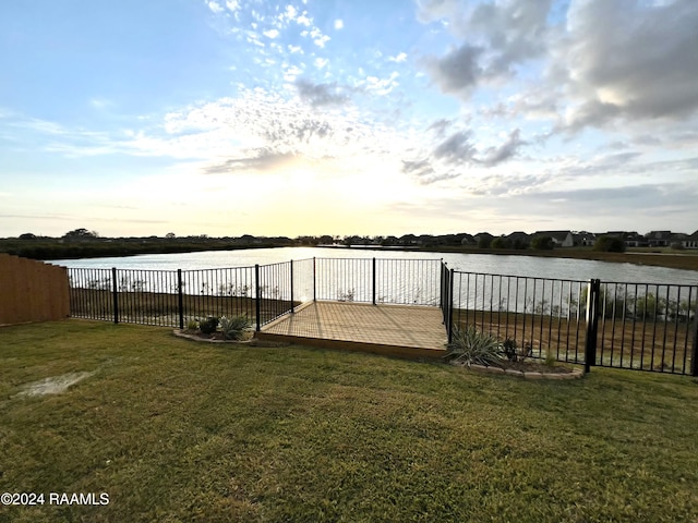 dock area with a water view and a lawn