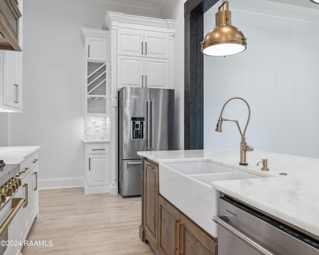 kitchen with light wood-type flooring, crown molding, decorative backsplash, white cabinets, and appliances with stainless steel finishes