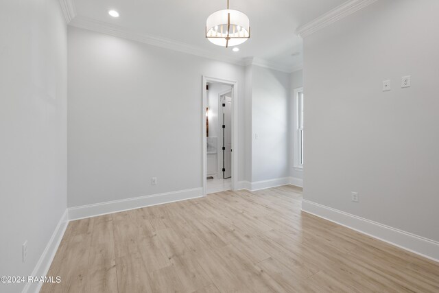 unfurnished room with a notable chandelier, light hardwood / wood-style flooring, and ornamental molding