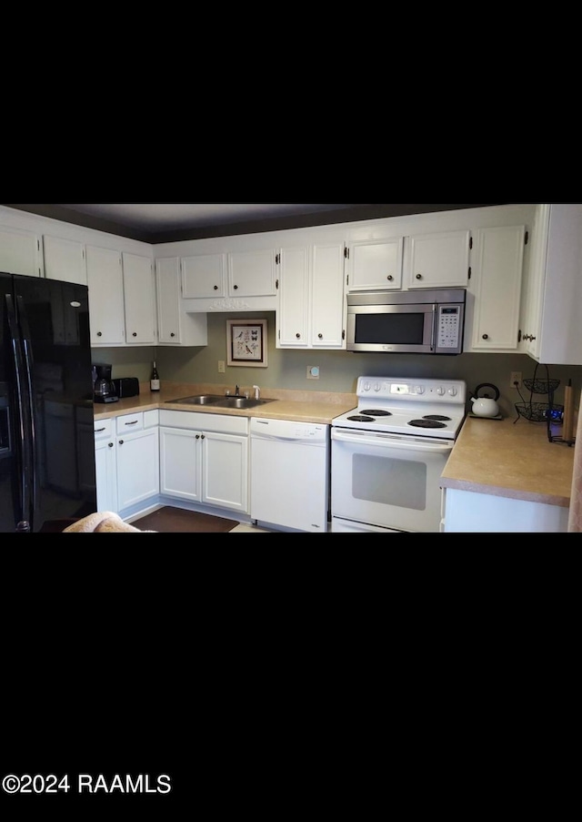 kitchen with white appliances, white cabinetry, and sink