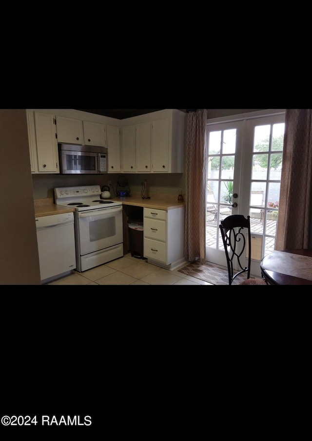 kitchen featuring french doors, light tile patterned floors, white appliances, and white cabinetry