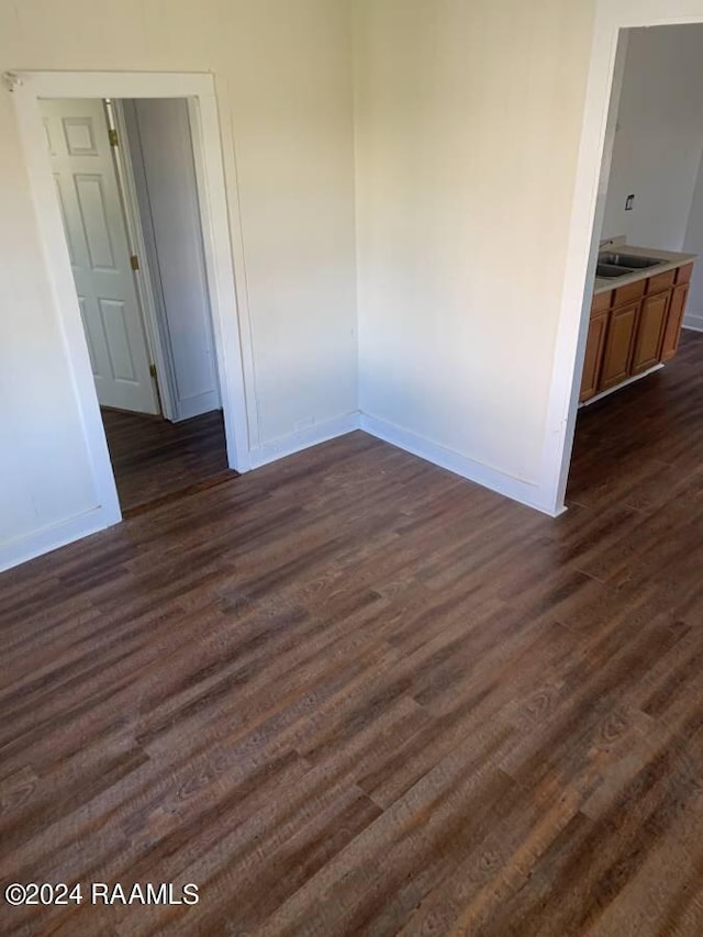 unfurnished room featuring dark hardwood / wood-style flooring and sink