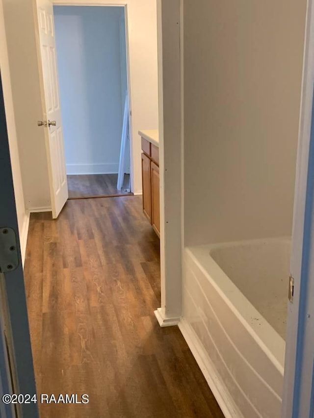 bathroom featuring a bathing tub, vanity, and hardwood / wood-style flooring