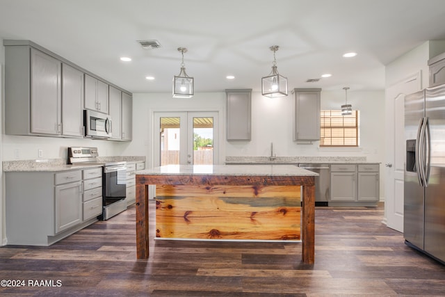 kitchen with gray cabinetry, appliances with stainless steel finishes, and hanging light fixtures