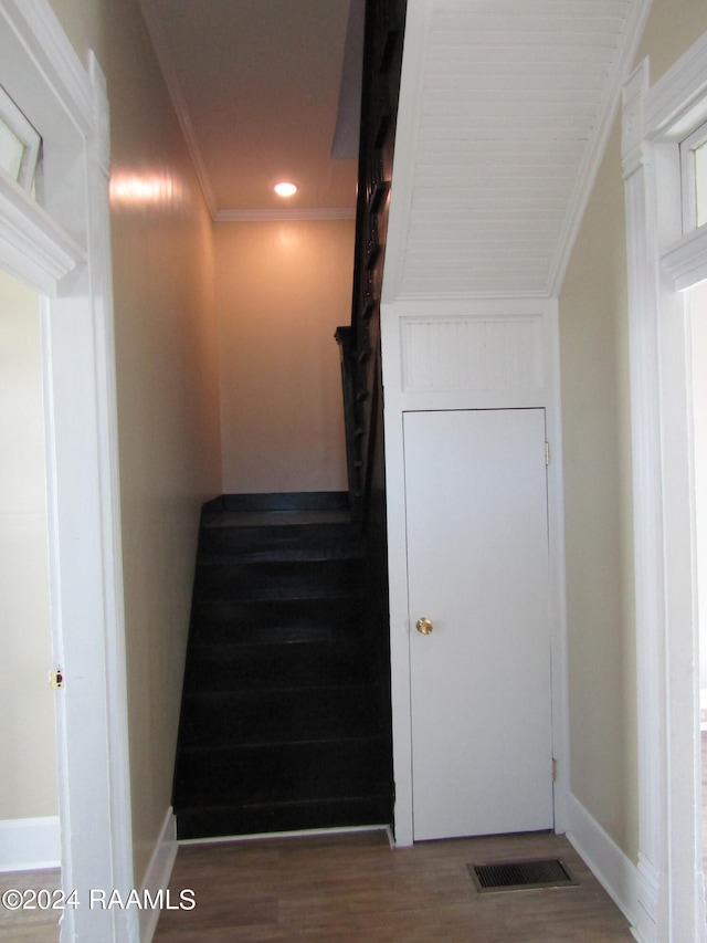 stairs with crown molding and wood-type flooring