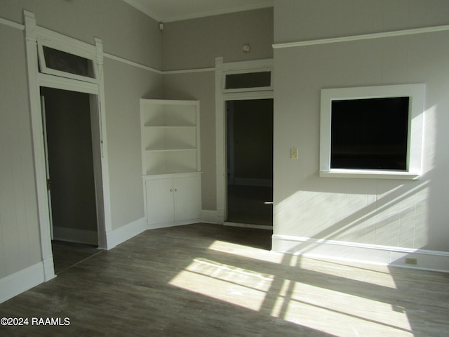 empty room featuring wood-type flooring and ornamental molding