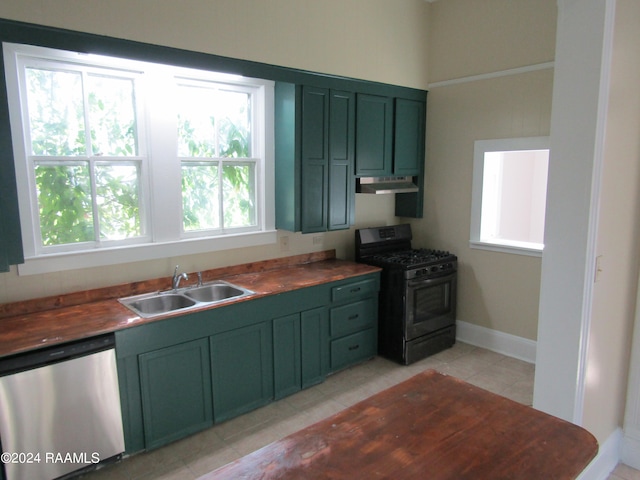 kitchen with wood counters, sink, green cabinetry, and appliances with stainless steel finishes