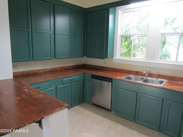 kitchen with a healthy amount of sunlight, wooden counters, dishwasher, and sink