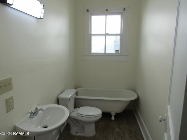 bathroom featuring toilet, sink, hardwood / wood-style floors, and a tub