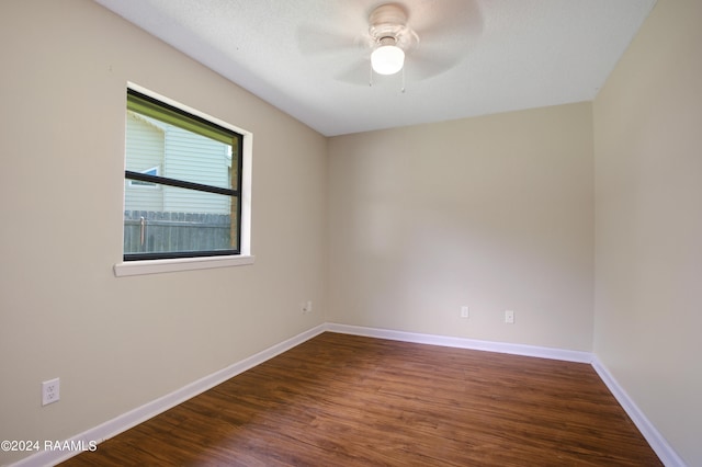 unfurnished room with dark hardwood / wood-style floors and ceiling fan