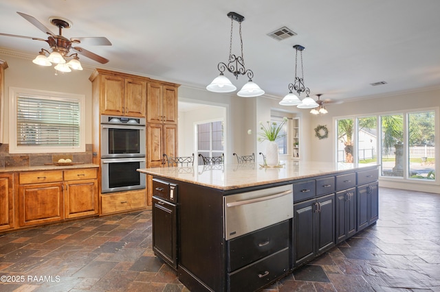 kitchen with crown molding, light stone counters, a center island, and stainless steel double oven