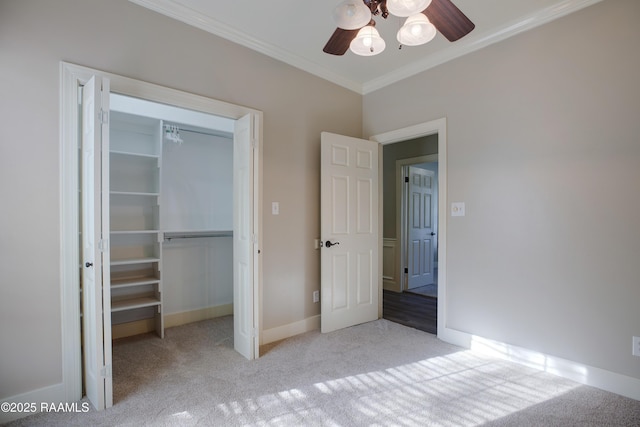 unfurnished bedroom featuring ceiling fan, a closet, crown molding, and light carpet