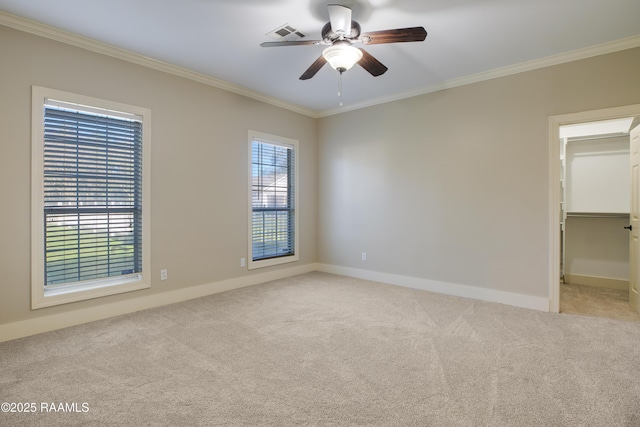 spare room featuring light carpet, ceiling fan, and crown molding